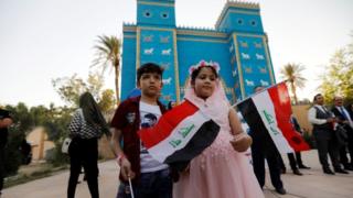 Watoto walioshikilia bendera ya Iraq wakati wa sherehe baada ya Unesco kuutambua mji wa Babylon kama la kistoria duniani