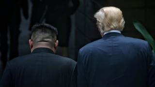 U.S. President Donald Trump walks with North Korean leader Kim Jong-un in back shot of their heads