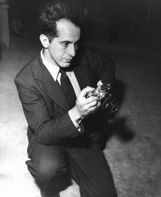 Robert Frank holding a pre-war Leica camera, 1954