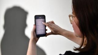 A staged photo of a person using the Australian government's coronavirus tracking app on a phone