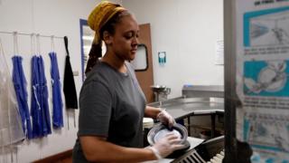 College student cleaning dishes