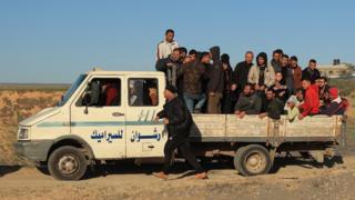 A large group of Palestinians fleeing Khan Younis stand in the back of a truck