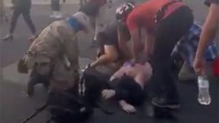 Люди помогают человеку, который был застрелен во время столкновений в Альбукерке (15.06.20)