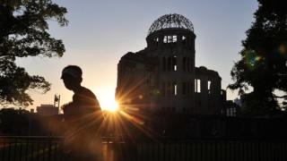 Мужчина несет мальчика мимо атомного купола Хиросимы (изображение из файла)