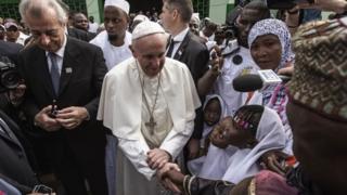 Папа Франциск (С) пожимает руку детям по прибытии в Центральную мечеть в районе PK5 30 ноября 2015 года в Банги