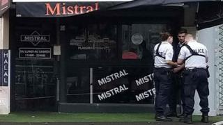 Police stand in front of the shop where a waiter was shot dead by a customer allegedly angry at having to wait for a sandwich, in the eastern Paris suburb of Noisy-le-Grand on August 17, 2019