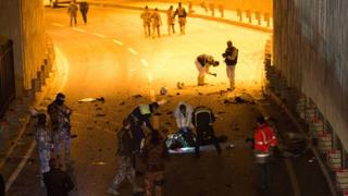 Un groupe de policiers encerclent le corps d'un suspect qu'ils ont abattu