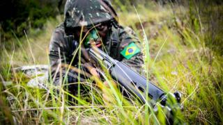 Militar com arma em punho