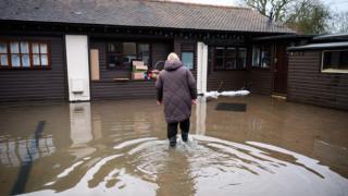 Doreen Cole surveys the damage to her property after heavy rains and sewer system overflows caused the River Cherwell to break its banks on Friday in Islip, Oxfordshire