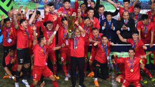 박항서 감독(가운데)이 15일(한국시간) 베트남 하노이의 미딩 국립경기장에서 2018 아세안축구연맹(AFF) 스즈키컵 우승 트로피를 들어 올리고 있다