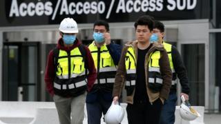 Workers leave the Mobile World Congress venue in Barcelona.