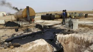Men work at a makeshift oil refinery site in Marchmarin town, southern countryside of Idlib, Syria December 16, 2015.
