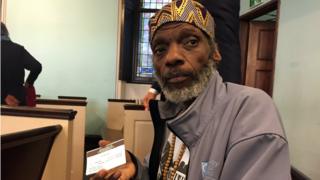 Reginald Smith holds his newly obtained voter identification card