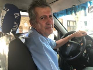 O taxista Marcelo Martínez posa para foto dentro do carro