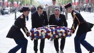 オランド現大統領(写真右)と共に無名戦士の墓で献花するマクロン次期大統領(8日、パリ)