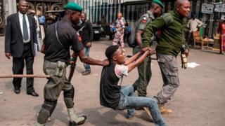 Soldiers dey drag young man for floor