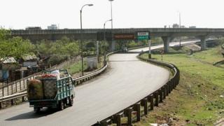 காலியாக கிடக்கும் சாலையில் சந்தைக்கு செல்லும் விவசாய விளைபொருள் ஏற்றிய வண்டி ஒன்று.