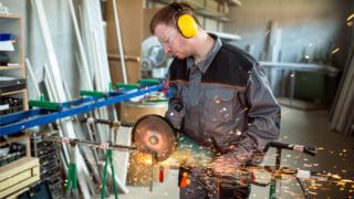 Worker cutting metal with grinder