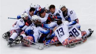 The United States Ice Hockey team embrace each other on the ice after they win gold against Canada