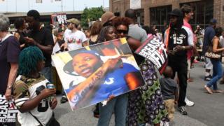 Kim Ford carries a picture of her son, Troy Biggus, who was murdered when he was 21