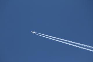Imagem mostra avião voando, deixando rastro de fumaça no céu