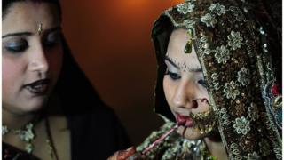 A Pakistani Hindu bride gets final touches from a relative at a mass-wedding ceremony in Karachi on January 2, 2015.