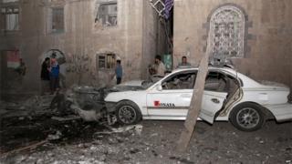 The wreckage of a car is seen at the site of a car bomb attack in the capital Sanaa on 29 June 2015.