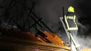 Пожарный занимается пожаром в доме