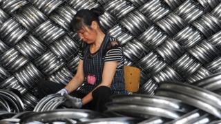 A woman works in a steel hub factory in China