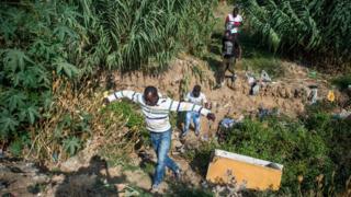 Migrants from Sub-Saharan Africa walk through a forest hiding from the police in the district of Boukhalef, on the southwestern outskirts of the Moroccan port city of Tangiers that overlooks the Strait of Gibraltar, on September 3, 2018. - In recent days, hundreds of security and special forces have cracked down on Sub-Saharan migrants in Boukhalef and the nearby district of Mesnana, resulting in several injuries according to several testimonials collected from migrants and locals.