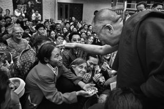 The courtyard between the temple and the palace complex is thronged with visitors. Here he talks to a Tibetan lady in need of a special blessing.