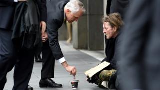 Prime Minister Malcolm Turnbull gives $5 to a beggar