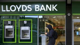 A man walks past a Lloyds Bank branch