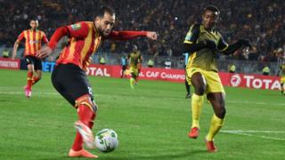 Sameh Derbali, joueur de l'Espérance de Tunis, en maillot rouge et or, joue contre le joueur de l'AS Vita Club, Mumuni Zakaria, vendredi 27 décembre 2019, à Radès.