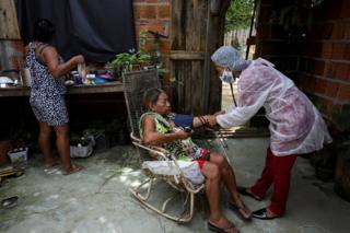 Vanderlecia examines a patient indoors