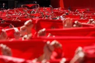 Revellers hold up their red handkerchiefs during the opening day of the San Fermin Running of the Bulls fiesta in Pamplona, Spain