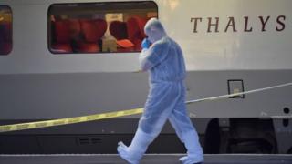 Forensic investigator walk next to the Thalys train after a foiled attack