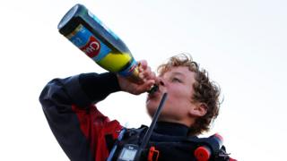 French skipper Tom Goron celebrates with fake champagne in Cherbourg-Octeville, northwestern France, on June 27, 2018