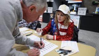 Caucus worker who supports Trump checks in voters
