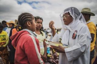 A woman takes Holy Communion