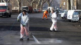 Workers clean bird poo off road