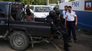 A handcuffed man, one of 174 fugitive inmates who had escaped the night before from a prison after killing a guard and stealing firearms, sits handcuffed on the back of a pick-up truck after local police and members of MINUSTAH arrested him, in Arcahaie, Haiti, October 23, 2016.