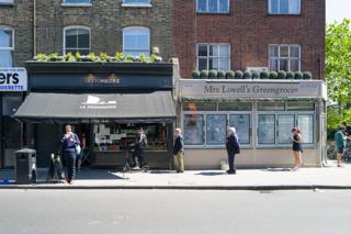 People queue down the street to get into a shop