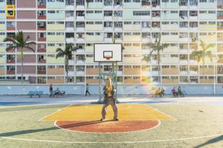 A man performs tai chi in front of a block of flats