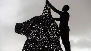 Egyptian Ibrahim Salah works on a statue of the ancient Egyptian goddess Bastet of scrap pieces in Giza on 19 February 2020.