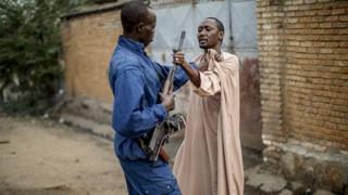Un homme empoigne l'arme d'un policier pour se défendre lors d'une mission de contrôle dans un quartier de Bujumbura