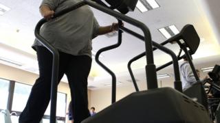 женщина с избыточным весом тренируется на беговой дорожке