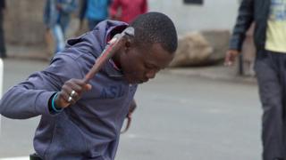 Man holding monkey wrench over Manuel Sithole