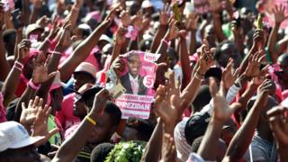 Demonstrators raising hands in the air, and carrying placards of the winner their candidate, Jovenel Moise