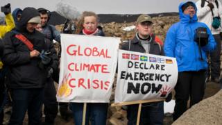 Climate-change-activitists-gathered-by-glacier-site-with-banners.